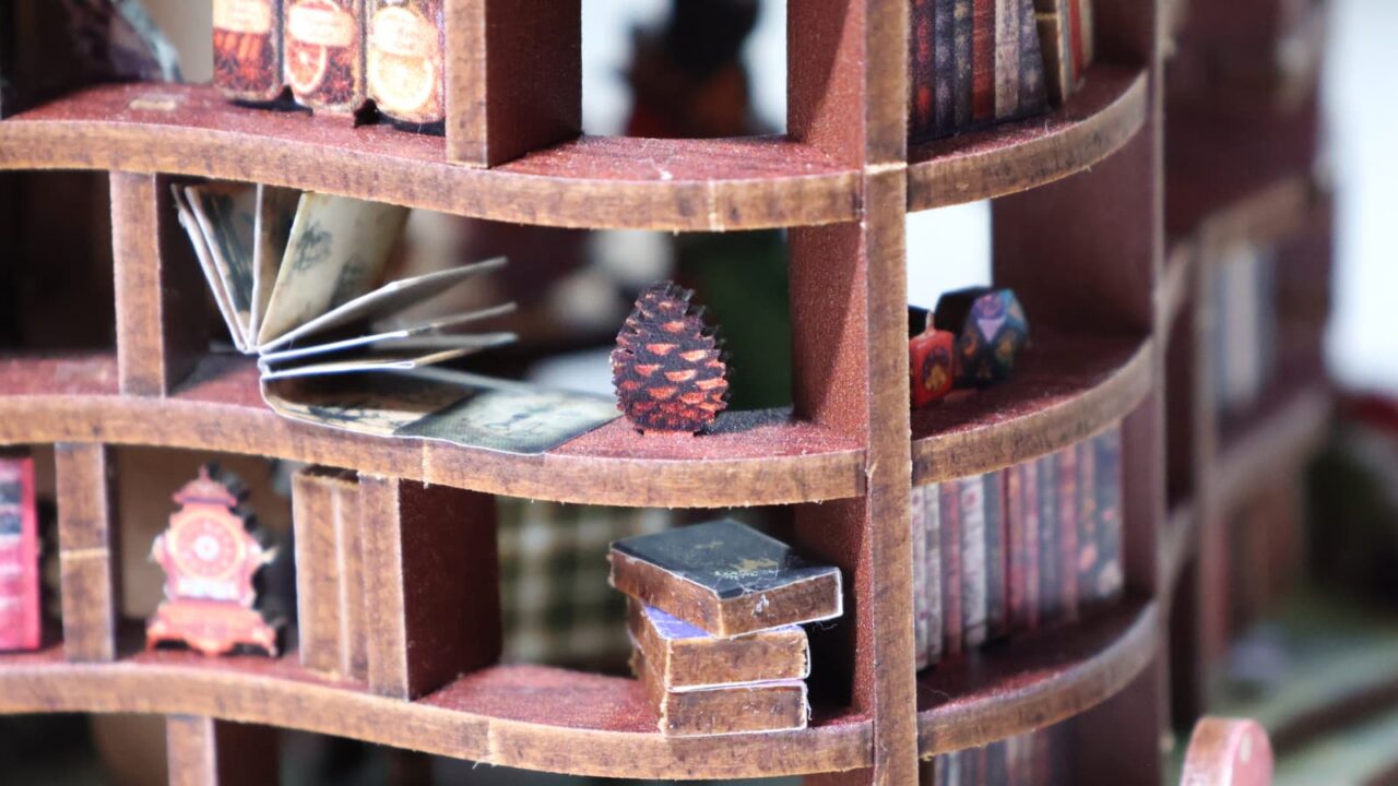 ミニチュア「森の図書館」部分接写（1階本棚新聞・松ぼっくり）